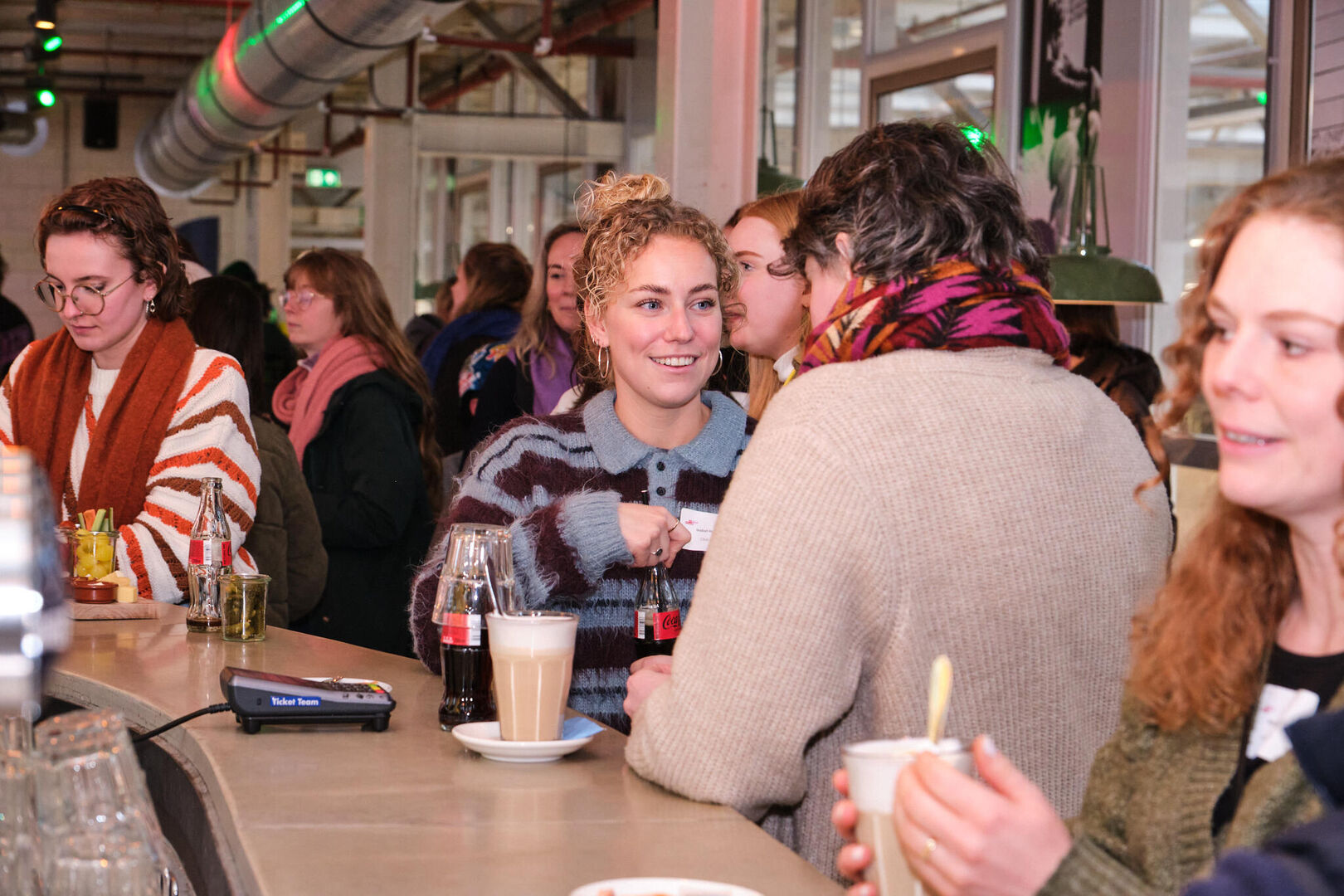 deelnemers praten na aan de bar
