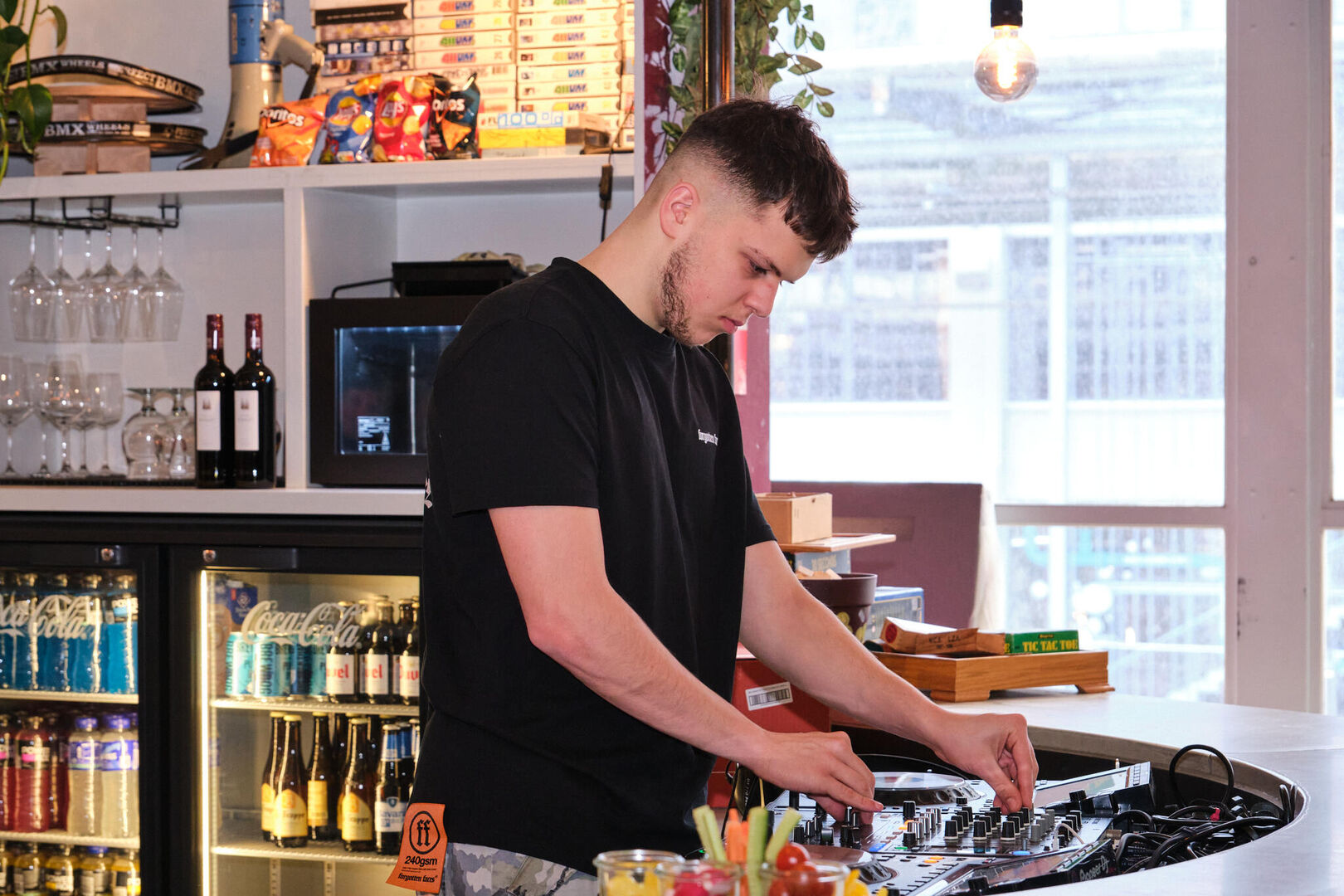 dj draait aan de knoppen van zijn mixer