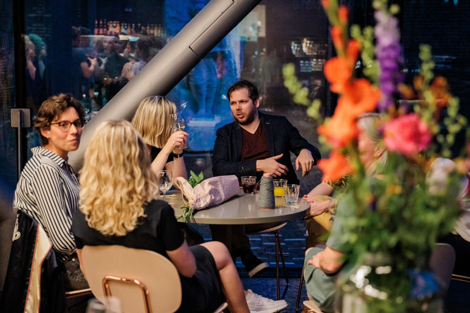 Vier mensen pratend aan tafel met borrel